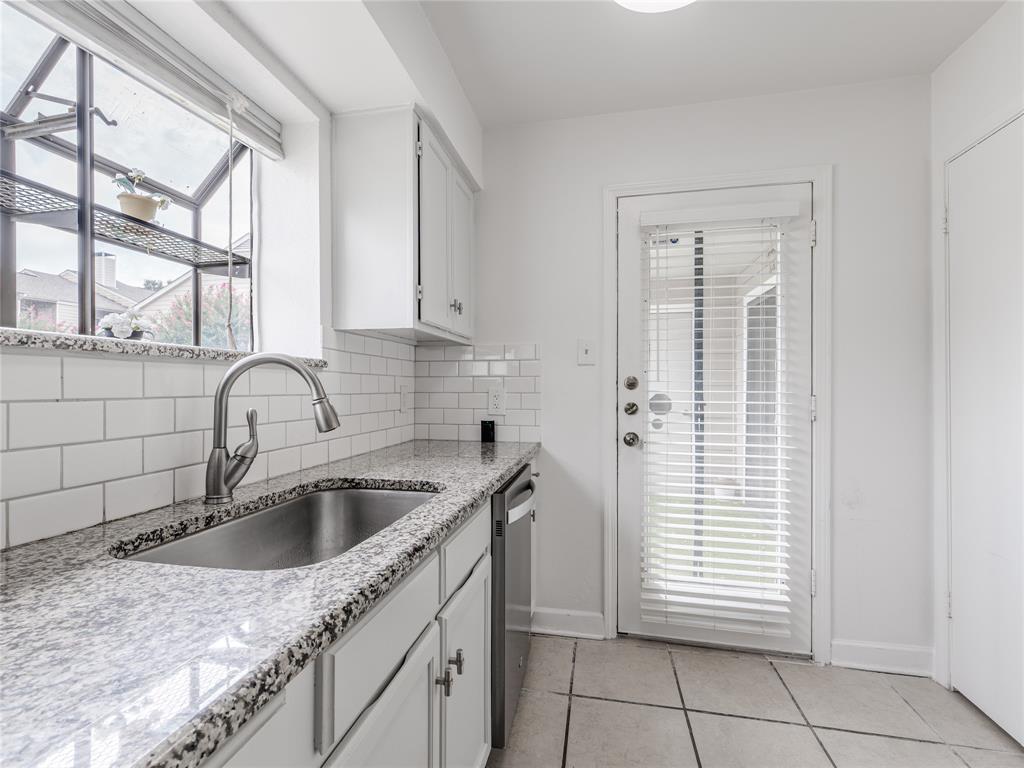 4748 Old Bent Tree Lane, Unit 201 Dallas, TX 75287 - Photo 13 of 17 Kitchen featuring backsplash, light stone countertops, white cabinets, light tile patterned floors, and dishwasher