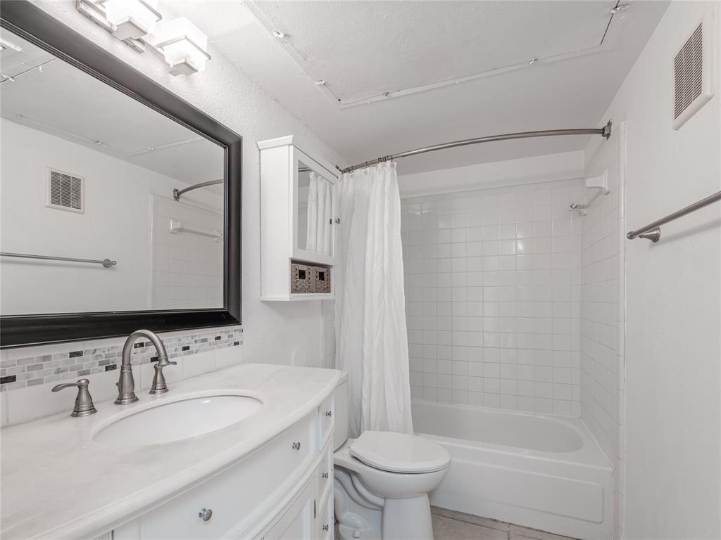 4748 Old Bent Tree Lane, Unit 201 Dallas, TX 75287 - Photo 8 of 17 Full bathroom with shower / tub combo with curtain, vanity, light tile patterned flooring, and backsplash