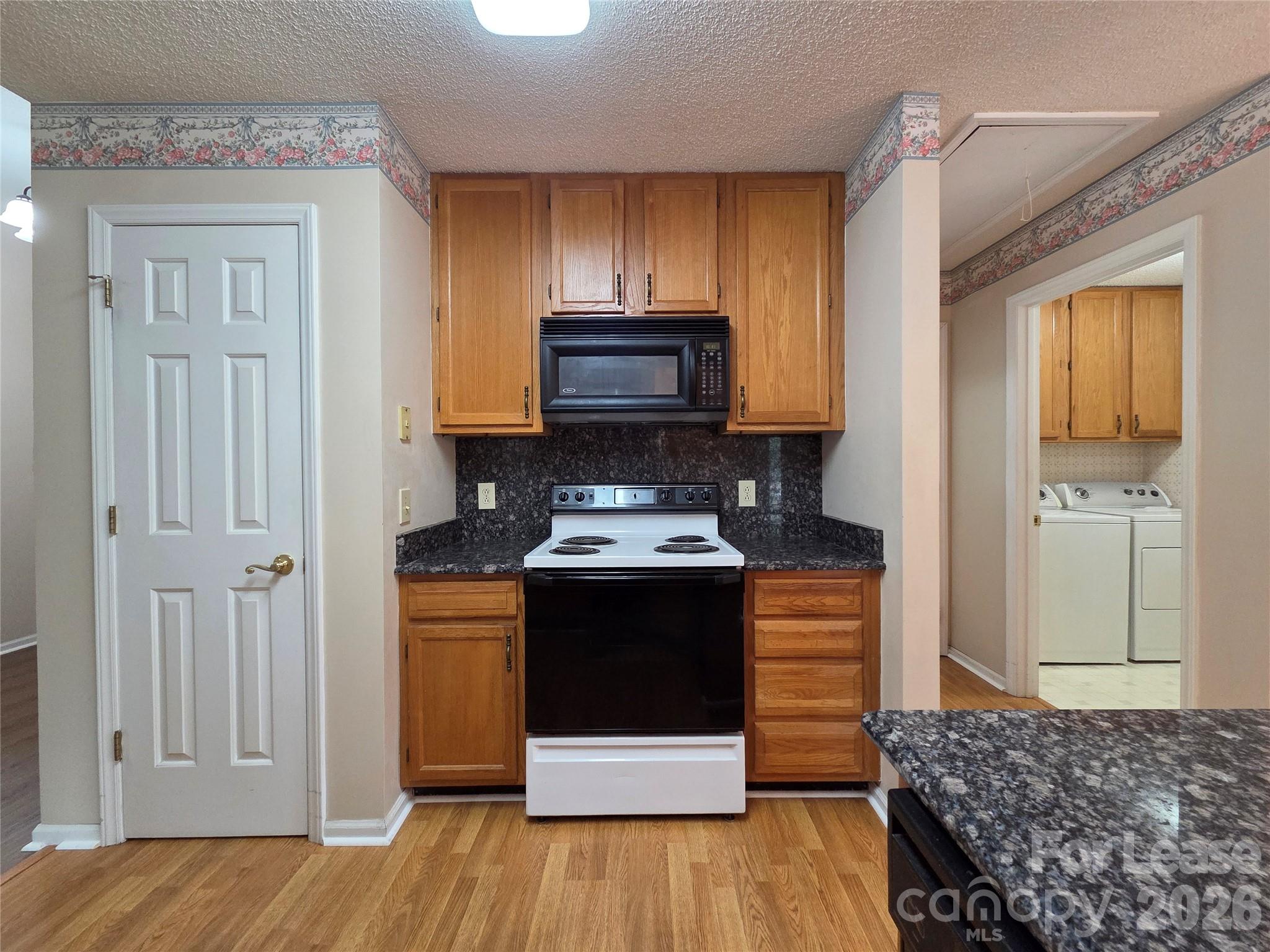 1319 Mistletoe Ridge Place Northwest Concord, NC 28027 - Photo 12 of 35 a kitchen with a stove and wooden floor