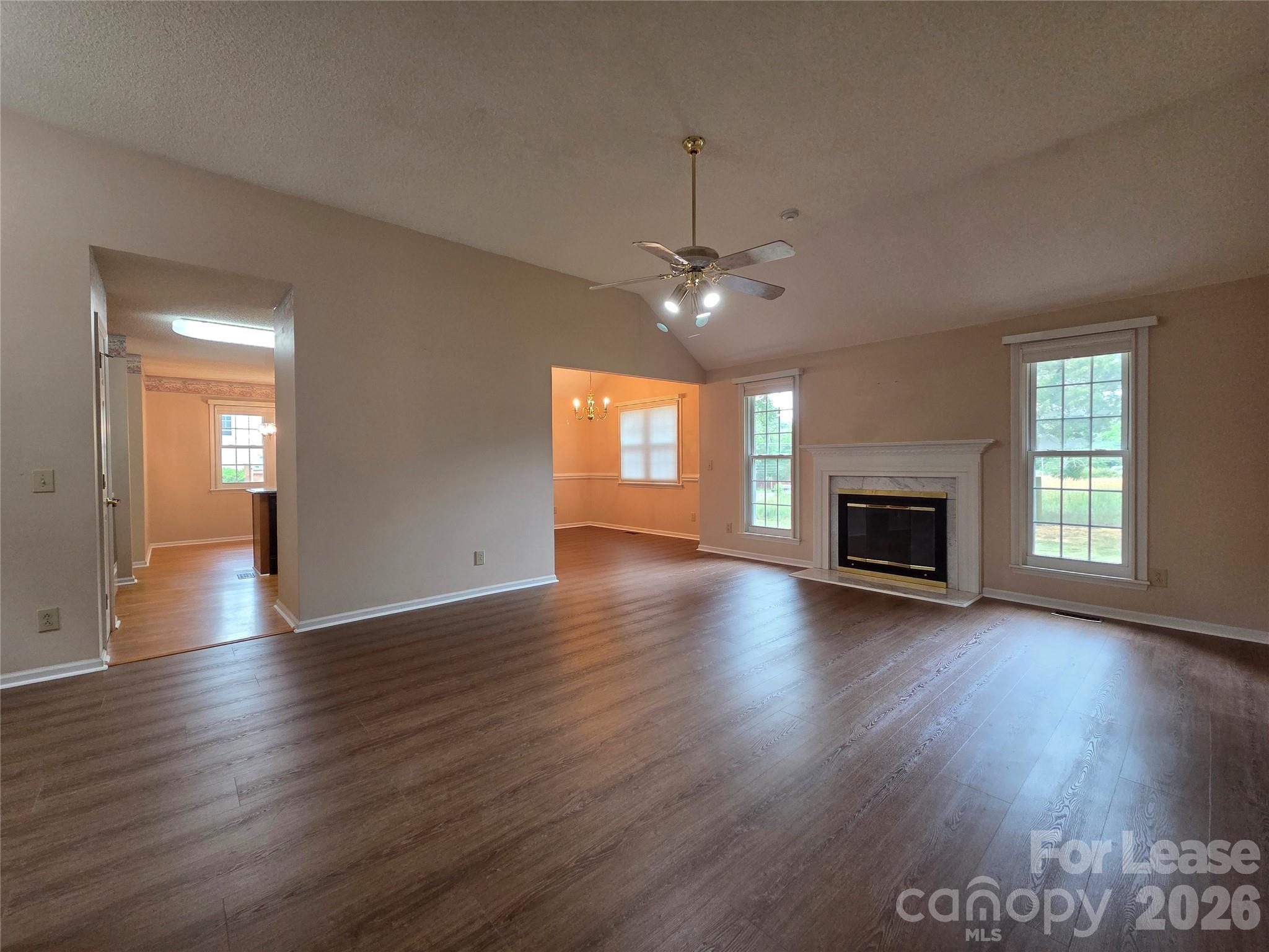 1319 Mistletoe Ridge Place Northwest Concord, NC 28027 - Photo 3 of 35 an empty room with wooden floor fireplace and windows