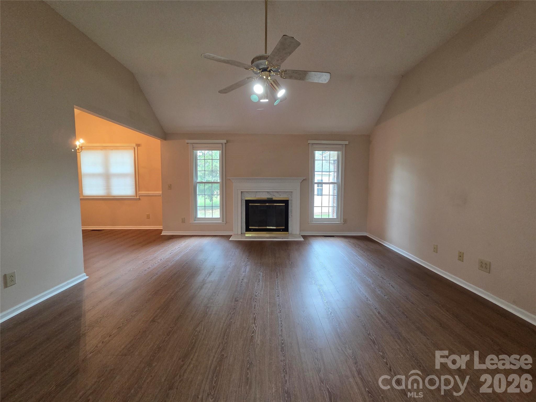 1319 Mistletoe Ridge Place Northwest Concord, NC 28027 - Photo 7 of 35 an empty room with wooden floor fireplace and windows