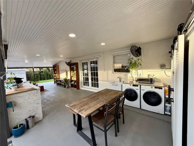 a dining hall with stainless steel appliances granite countertop a stove and a dining table with kitchen view