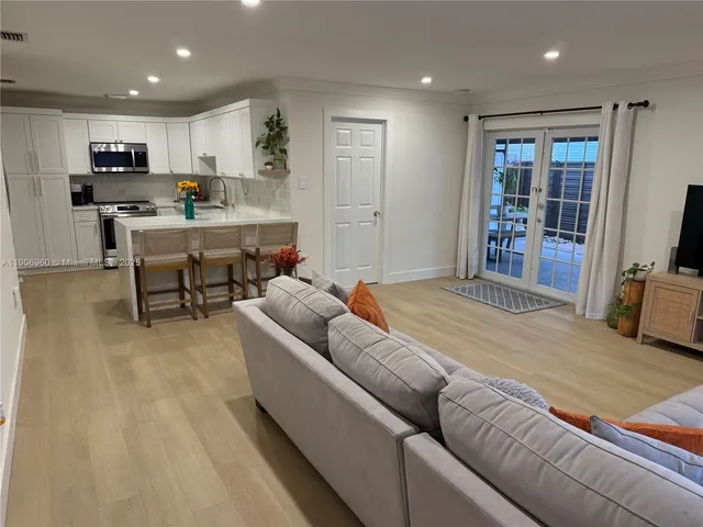 a living room with kitchen furniture and a flat screen tv