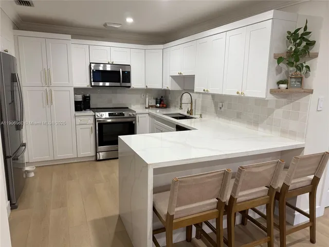 a kitchen with a table chairs microwave and cabinets