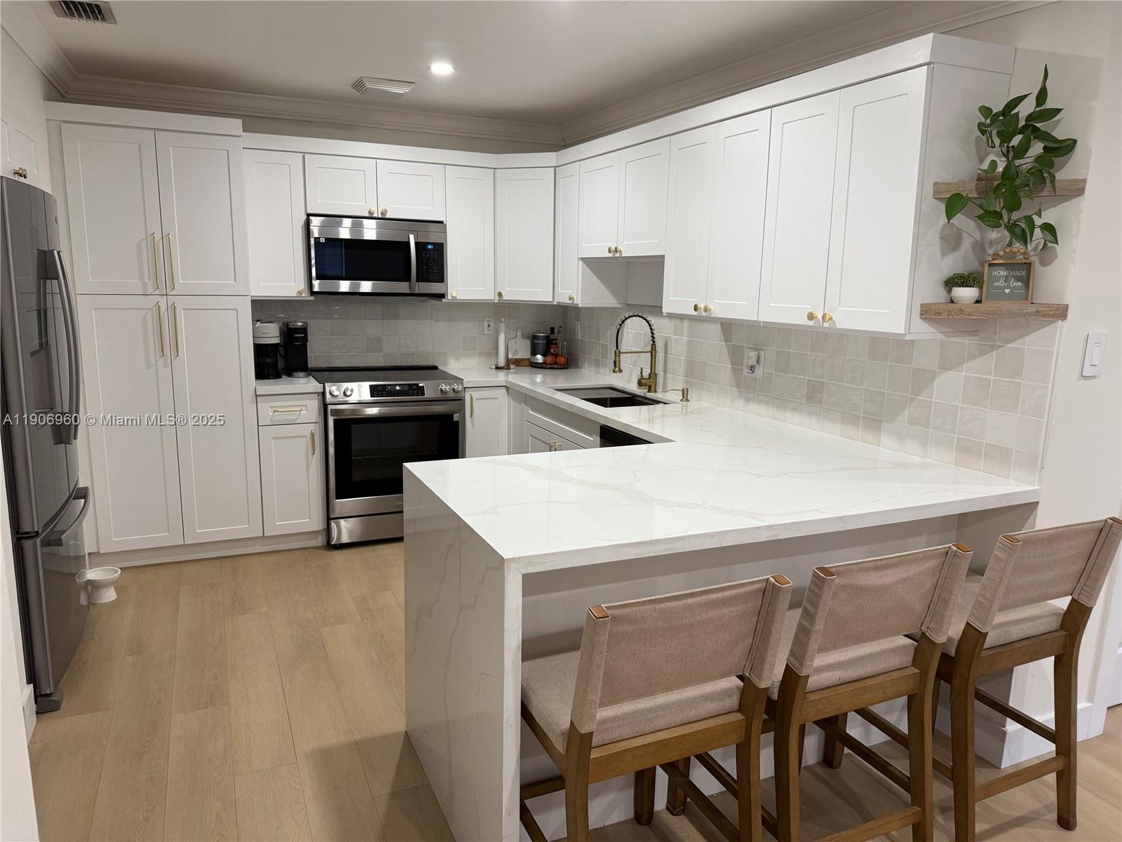 20912 Southwest 125th Avenue Road Miami, FL 33177 - Photo 8 of 25 a kitchen with a table chairs microwave and cabinets