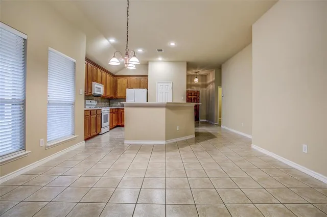 a view of a kitchen with refrigerator and a sink