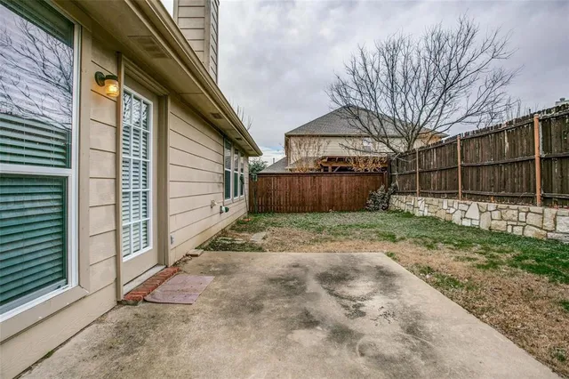 a view of a yard with wooden fence