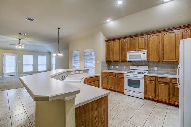 a kitchen with stainless steel appliances granite countertop a sink counter space cabinets and a stove