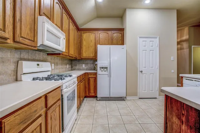 a kitchen with stainless steel appliances granite countertop a refrigerator and a stove