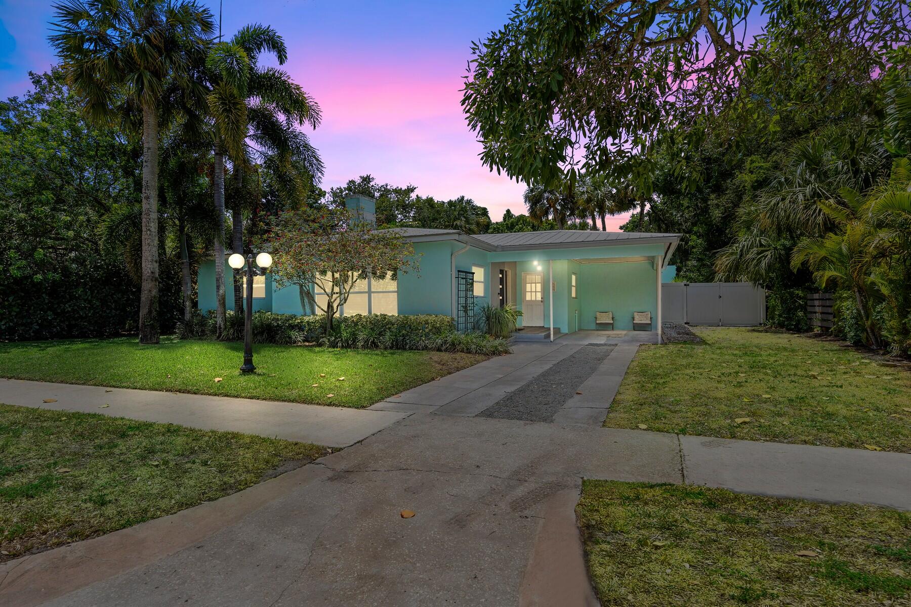 a front view of a house with a yard and potted plants