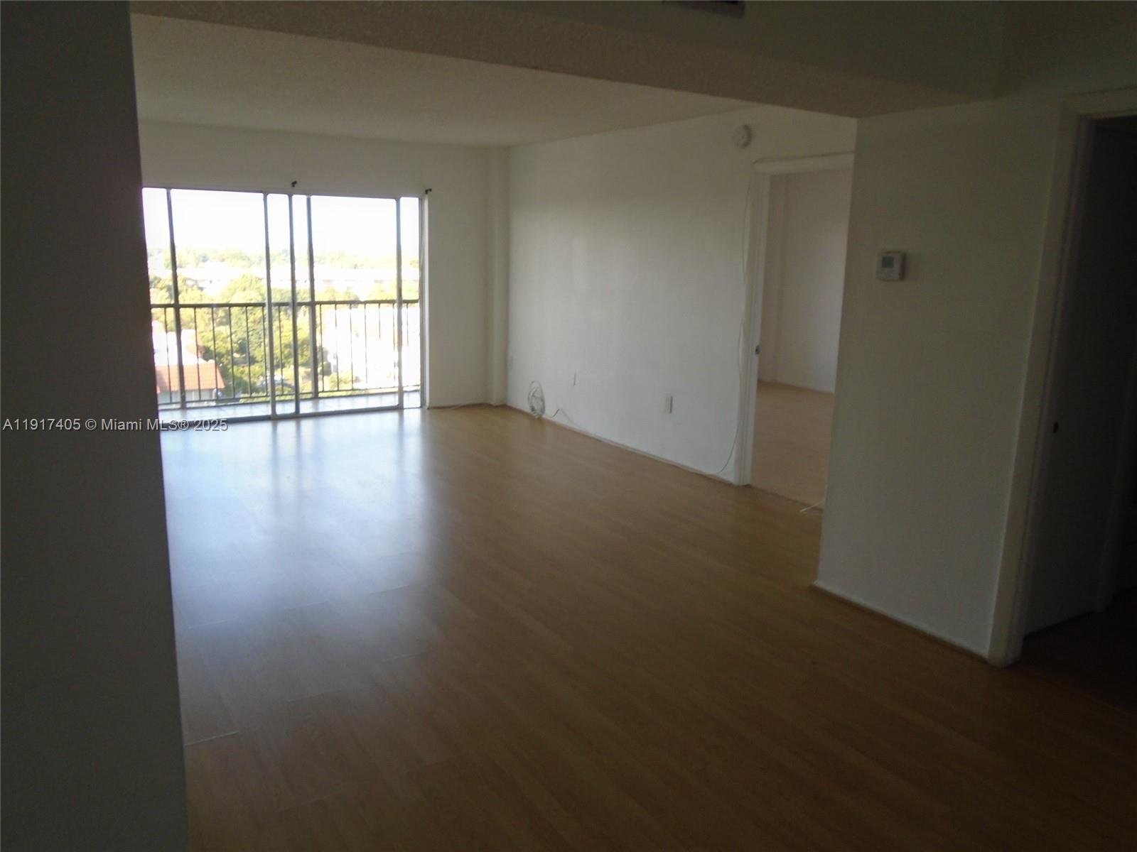 4174 Inverrary Drive, Unit 1003 Lauderhill, FL 33319 - Photo 27 of 28 a view of an empty room with wooden floor and a window