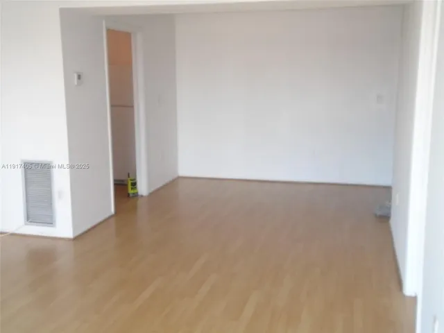 a view of a room with wooden floor