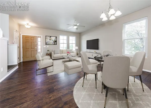 a living room with furniture a chandelier and a flat screen tv