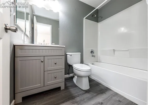 a bathroom with a toilet sink a mirror and vanity