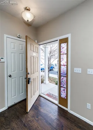 a view of a hallway with wooden floor and cabinet