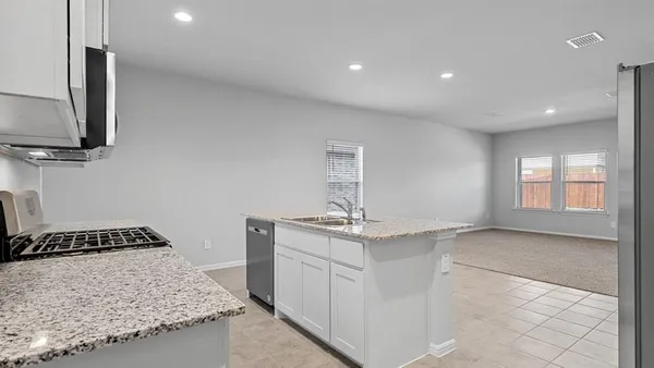 a kitchen with stainless steel appliances granite countertop a stove a sink and a refrigerator