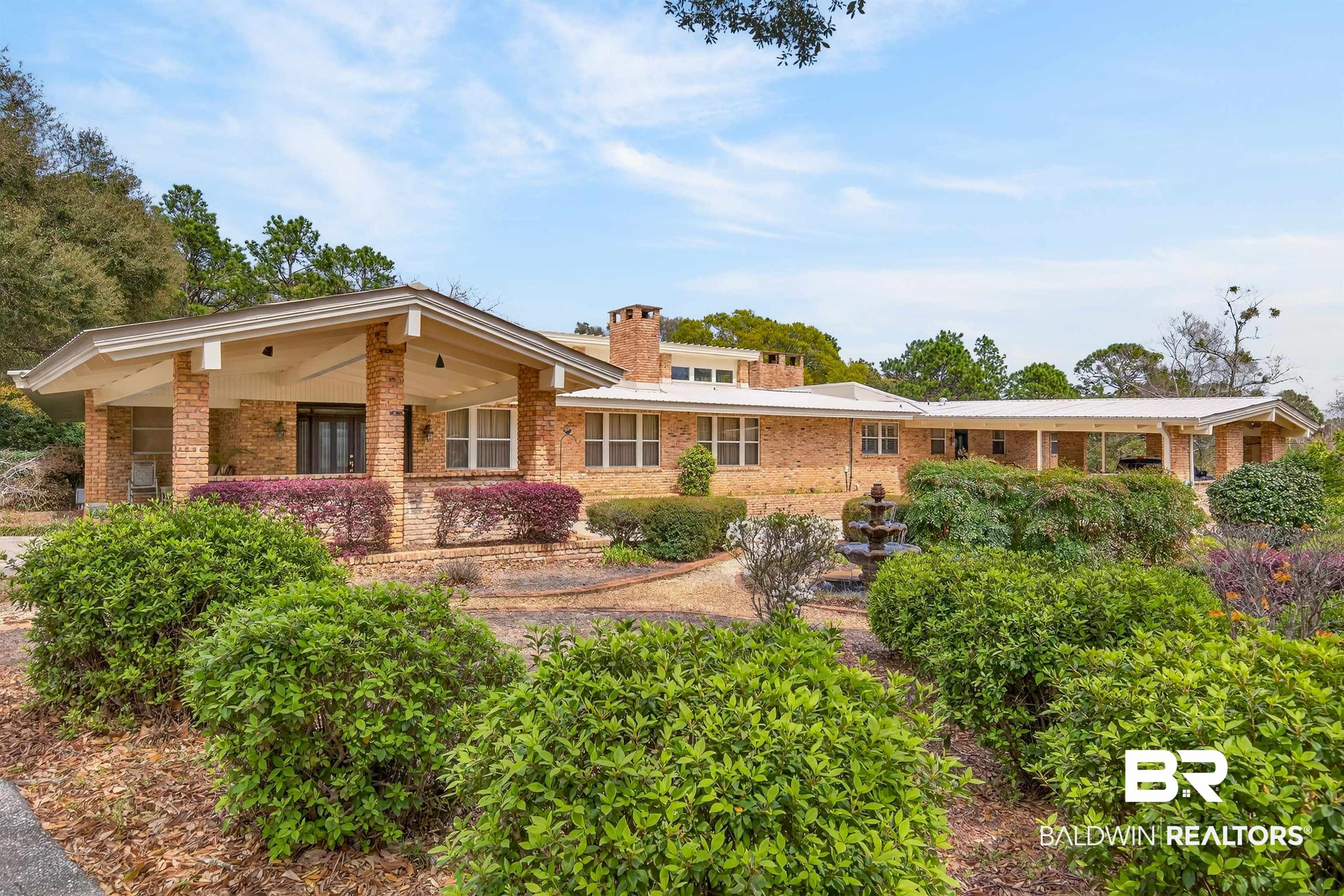3175 Dawes Lake Road Mobile, AL 36619 - Photo 75 of 92 Rear view of house featuring brick siding, covered porch, and a chimney