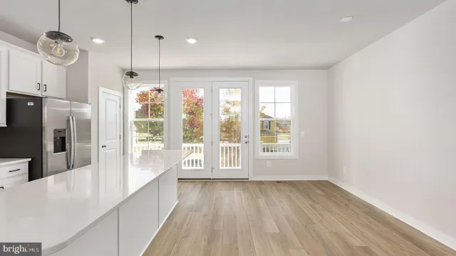 a large kitchen with a large window a oven a counter space and stainless steel appliances