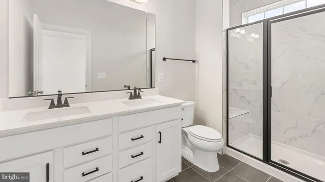 a bathroom with a double vanity sink toilet and shower