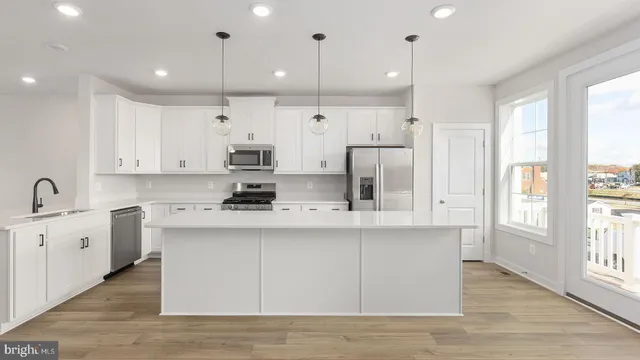 a kitchen with stainless steel appliances granite countertop a sink a stove and a refrigerator