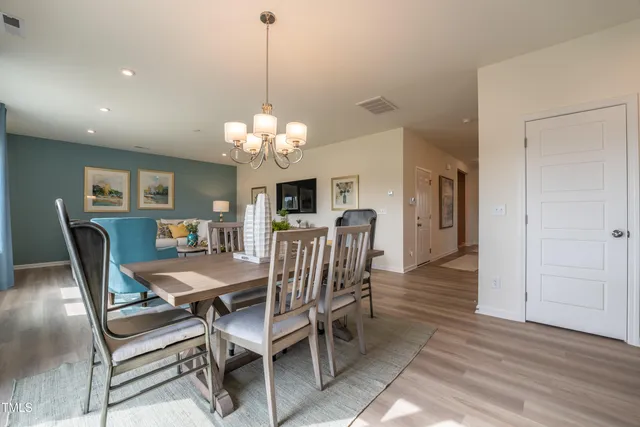 a dining room with furniture a chandelier and wooden floor