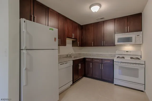 a kitchen with granite countertop a sink cabinets and utility