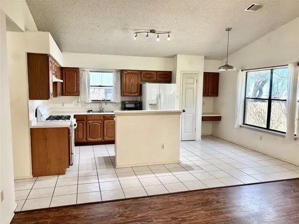 a kitchen with stainless steel appliances granite countertop a stove a sink and a refrigerator