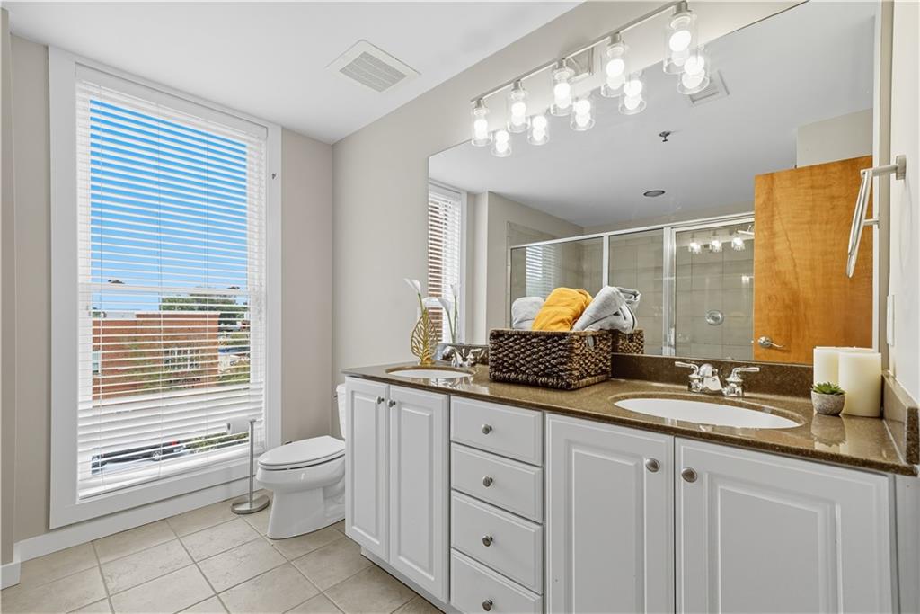 1133 Church Street, Unit 2 Covington, GA 30014 - Photo 23 of 38 a bathroom with a granite countertop double vanity sink a mirror and a bathtub