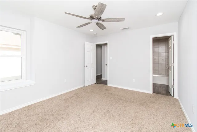 a view of an empty room and a ceiling fan