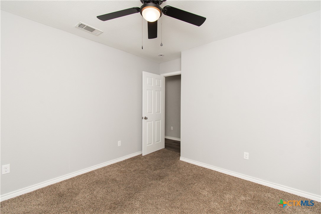 2610 San Jacinto Road Temple, TX 76502 - Photo 17 of 24 an empty room with a ceiling fan and carpet