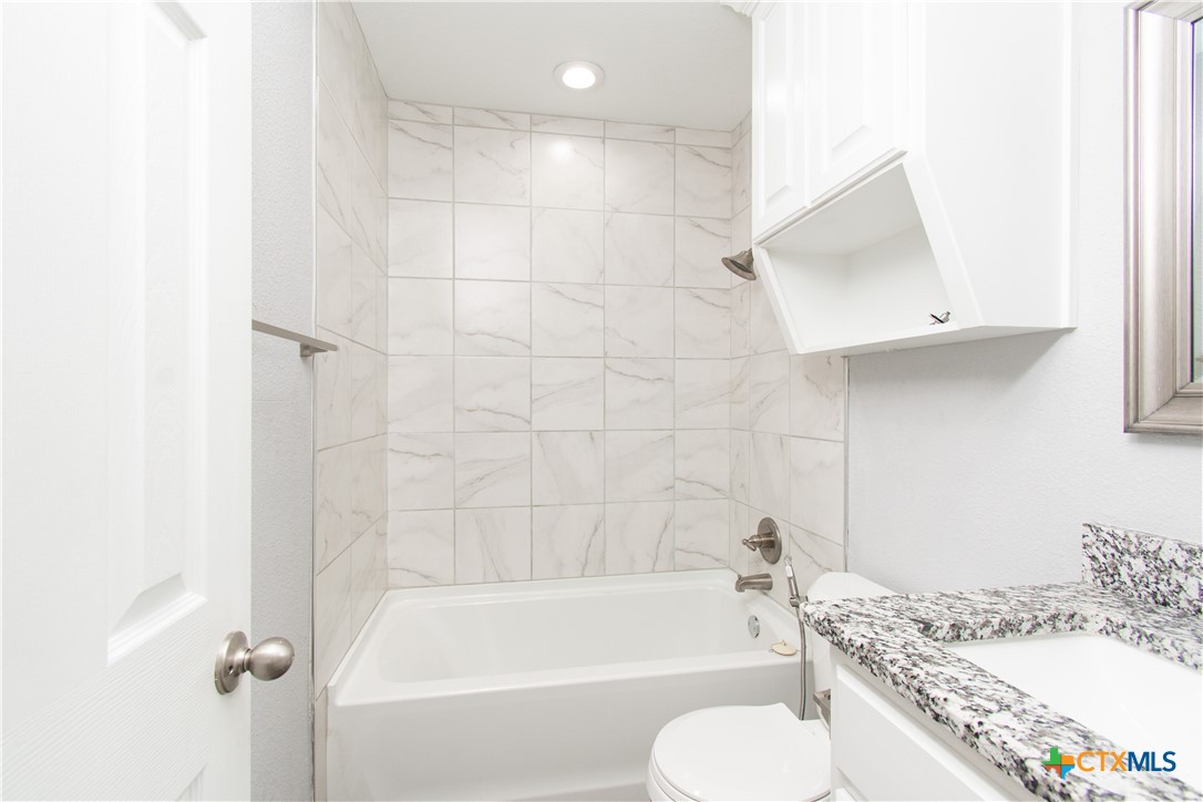 2610 San Jacinto Road Temple, TX 76502 - Photo 18 of 24 a bathroom with a granite countertop bathtub shower sink vanity and toilet