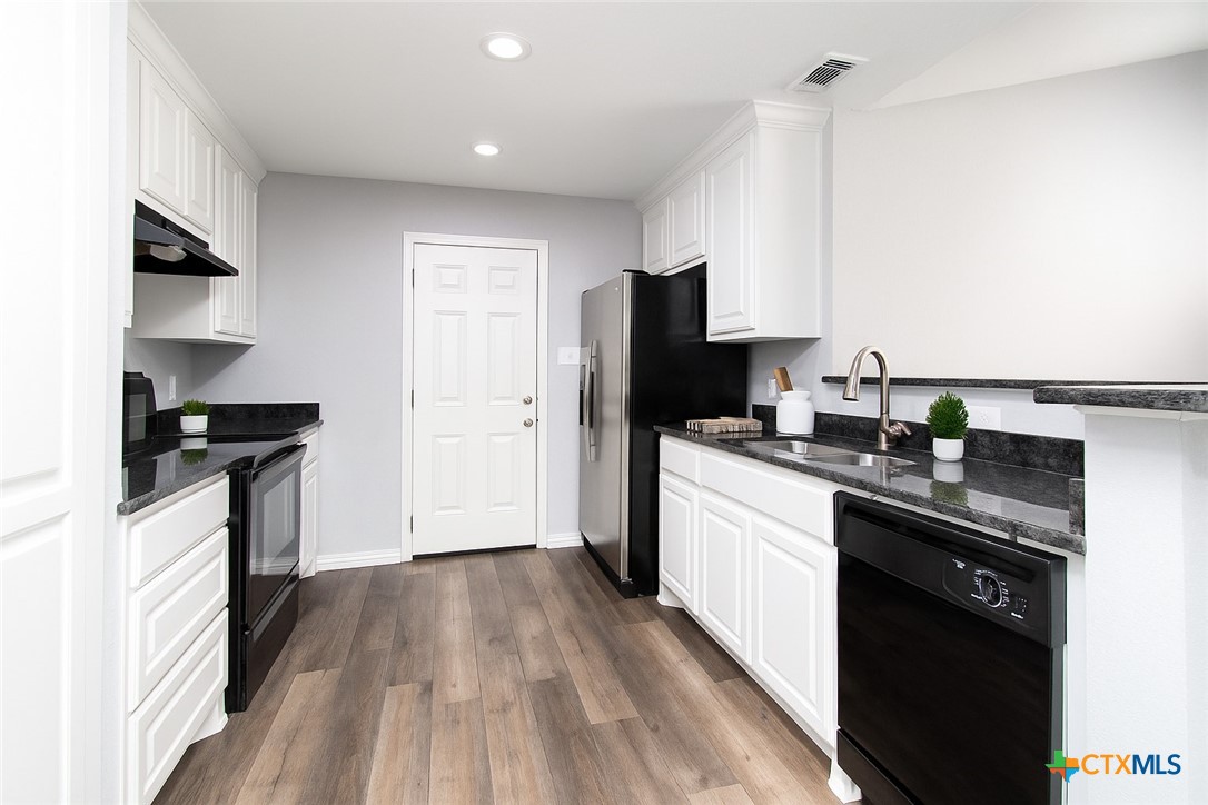 2610 San Jacinto Road Temple, TX 76502 - Photo 9 of 24 a kitchen with a sink a refrigerator and cabinets