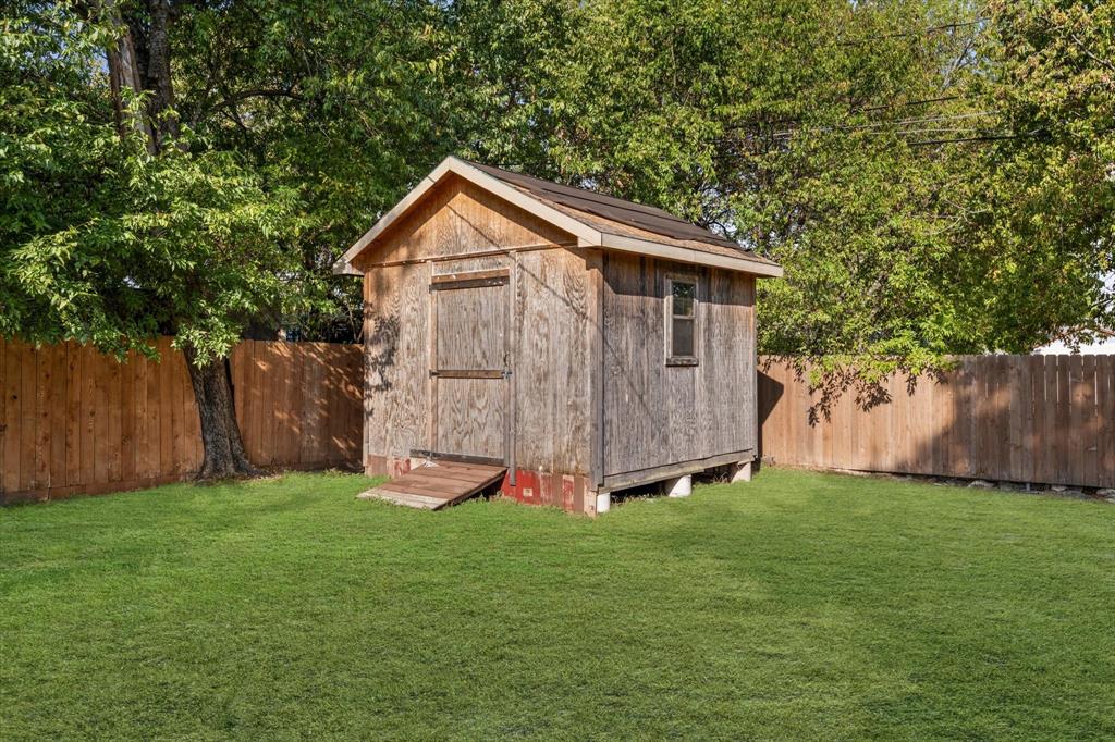 3605 Rolando Avenue Waco, TX 76711 - Photo 15 of 17 Expansive green lawn featuring a wooden storage shed with a window and solid wood fencing