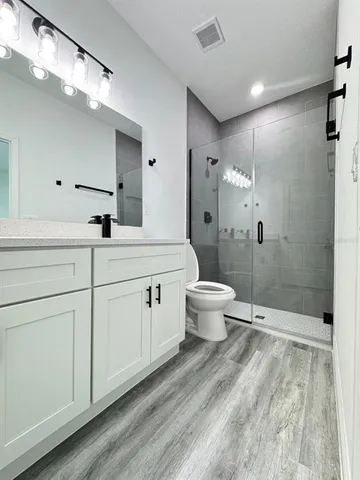 a spacious bathroom with a double vanity sink toilet and shower