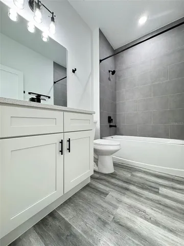 a bathroom with a toilet a sink a mirror and shower