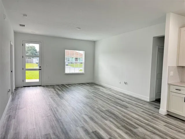 an empty room with window and wooden floor