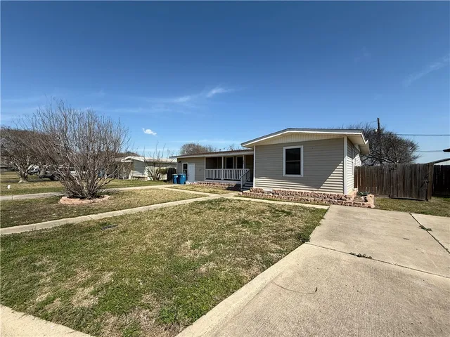 an empty room with wooden floor chandelier fan and windows