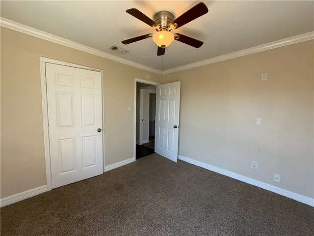 an empty room with wooden floor chandelier and windows