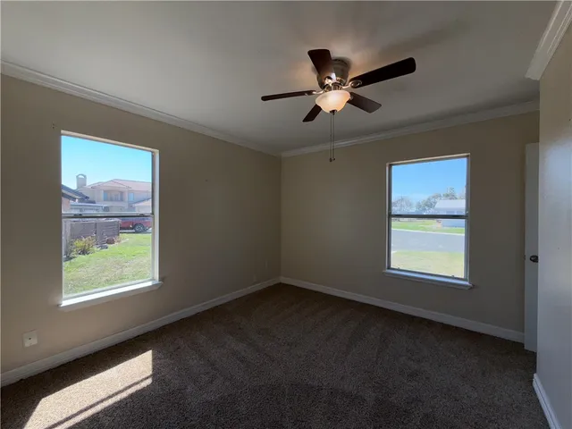an empty room with a window and a ceiling fan