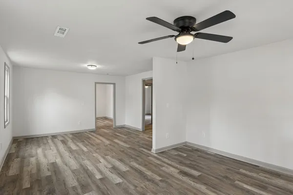 a view of empty room with wooden floor