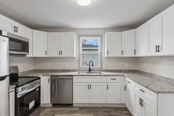 a kitchen with white cabinets stainless steel appliances and sink
