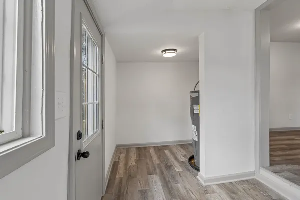 a view of a hallway with wooden floor and staircase