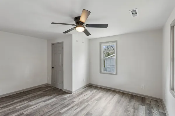 a view of empty room with wooden floor