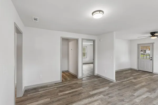 an empty room with closet and windows
