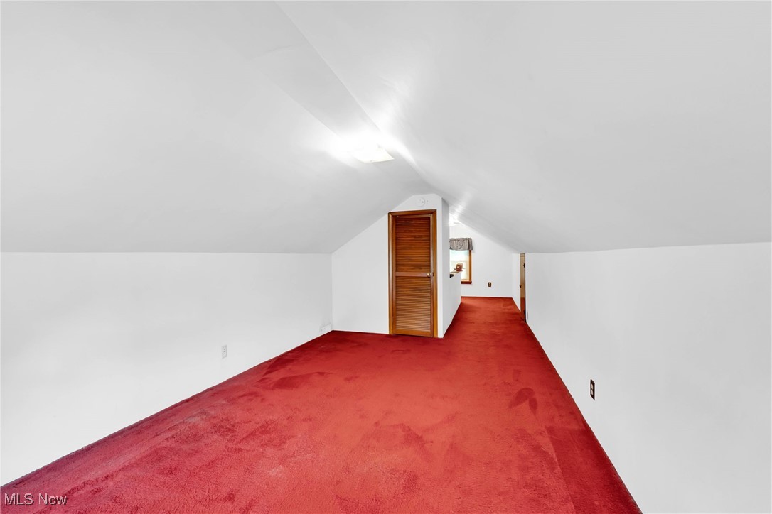 390 Hilliard Road Elyria, OH 44035 - Photo 20 of 30 Bonus room with dark carpet and vaulted ceiling
