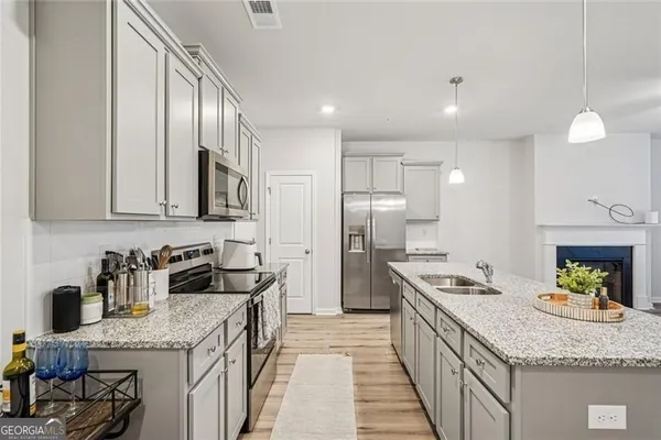 a kitchen with granite countertop stainless steel appliances a sink stove and refrigerator