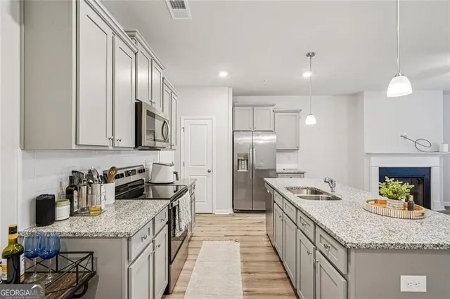 a kitchen with granite countertop stainless steel appliances a sink stove and refrigerator