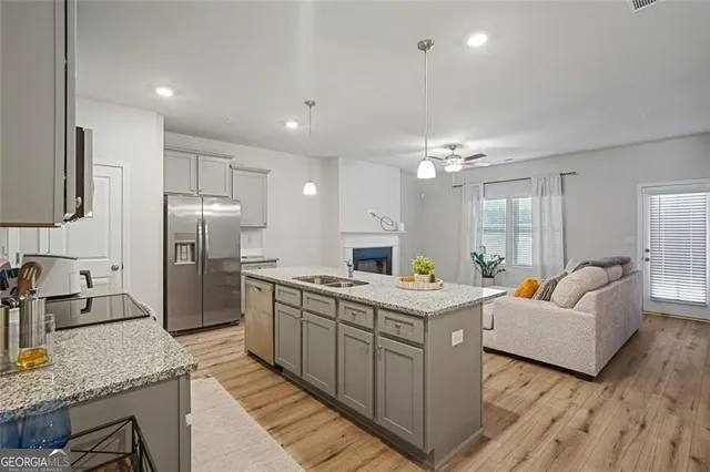 a kitchen with stainless steel appliances granite countertop a sink stove and refrigerator
