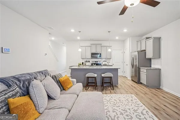 a living room with kitchen island furniture and a kitchen view