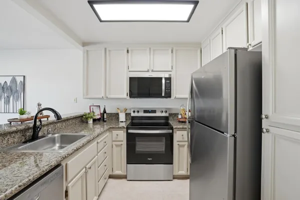 a kitchen with stainless steel appliances granite countertop a sink stove and refrigerator